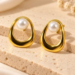 Elara Pearl Orbit anti-tarnish stud earrings with white pearls and sculptural gold open-loop frames