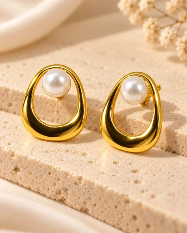 Elara Pearl Orbit anti-tarnish stud earrings with white pearls and sculptural gold open-loop frames