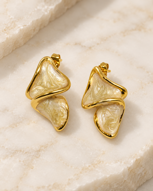 Close-up of Aurelia Ripple gold earrings showing textured pearlescent ivory inlays and curved frames
