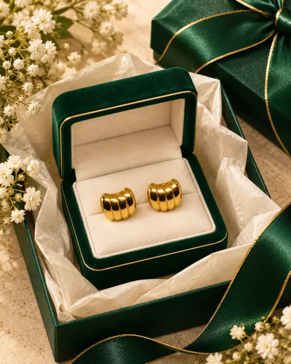 Gold ribbed dome stud earrings displayed in a green jewellery box with ribbon and flowers