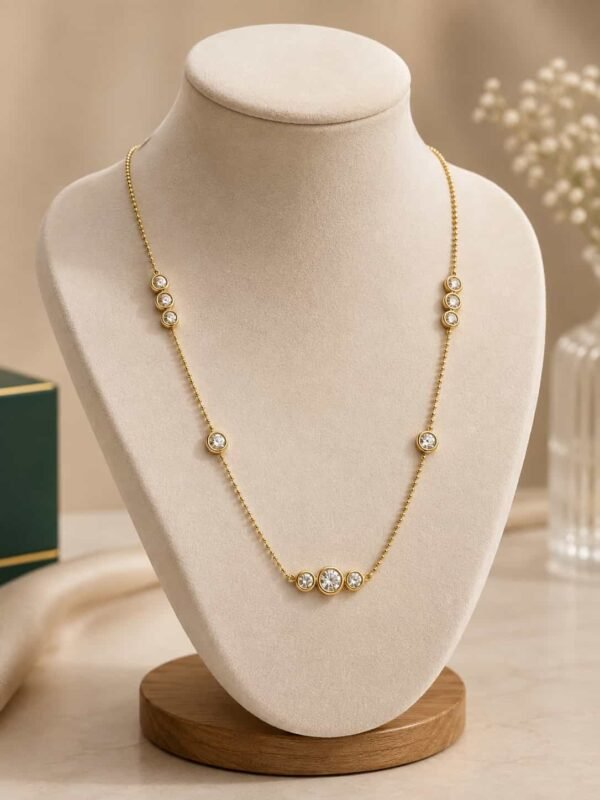 Aurelia delicate gold-tone CZ station necklace displayed on an ivory jewellery bust