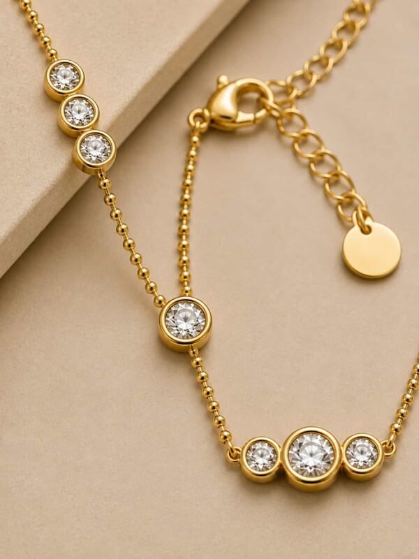 Close-up of Aurelia necklace clear bezel-set CZ stones, fine beaded chain, lobster clasp and extender