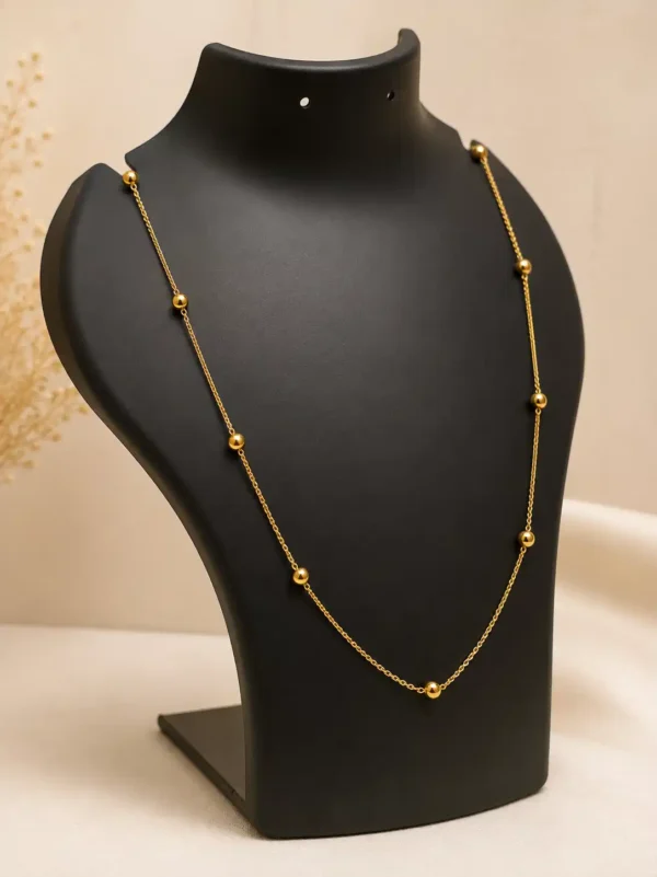 Solene gold bead necklace displayed on black jewellery bust showing delicate everyday proportions
