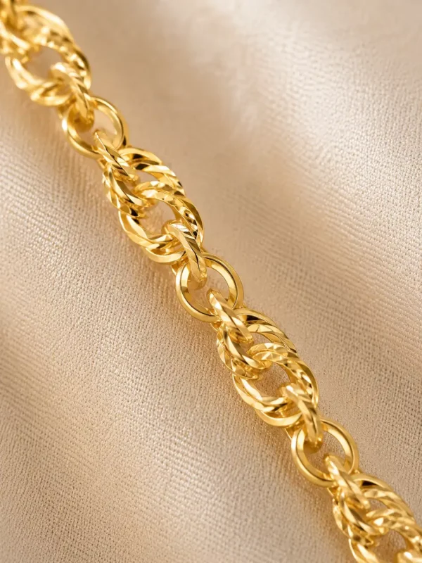 Close-up of Mirelle gold chain with alternating polished oval links and textured twisted rope-like links