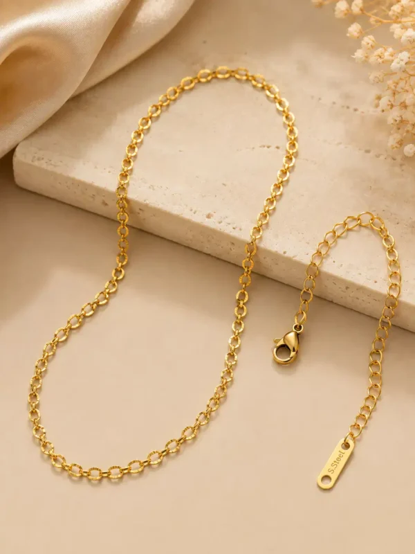 Aurelia gold loop chain necklace close-up showing textured oval links, lobster clasp and adjustable extension chain