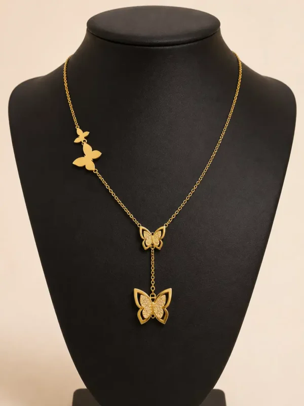 Gold butterfly drop pendant necklace displayed on black jewellery bust
