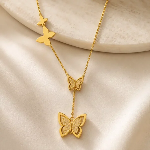 Close-up of gold butterfly drop necklace with detailed centre and hanging butterfly pendants