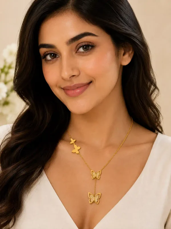 Woman styling gold butterfly drop pendant necklace with elegant white outfit
