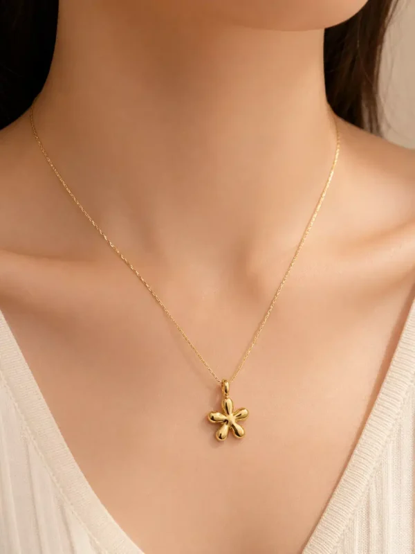 Woman wearing Aurelia Bloom anti-tarnish gold floral pendant necklace