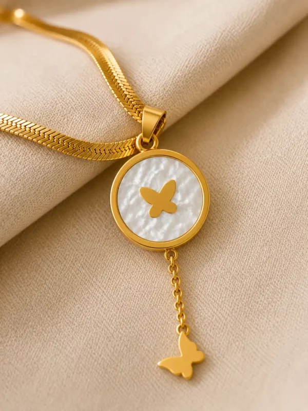 Close-up of Liora Flutter white pearlescent butterfly pendant and gold chain