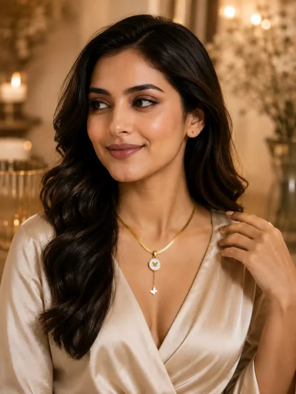 Woman styling Liora Flutter gold butterfly necklace with an elegant neutral outfit