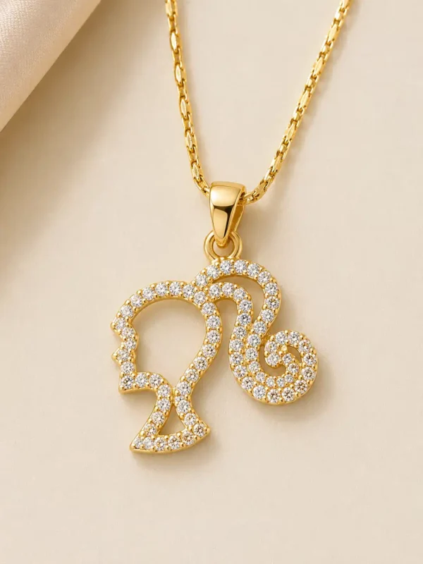 Close-up of gold-tone feminine silhouette pendant outlined with small clear crystals on the Muse necklace