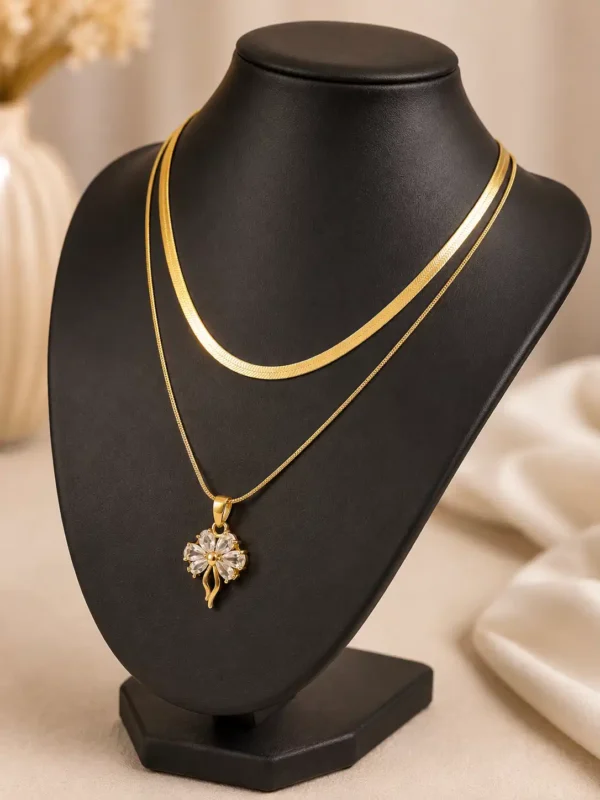Angled view of Elara anti-tarnish layered gold necklace with crystal floral pendant on black jewellery bust