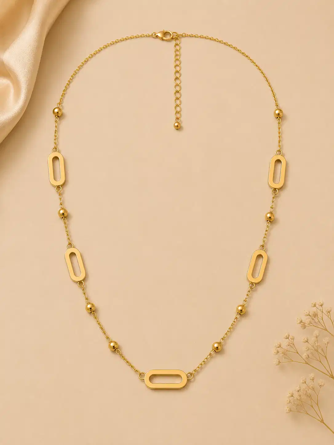 Full view of Aurelia gold link and bead station necklace with five open links, lobster clasp and extender chain