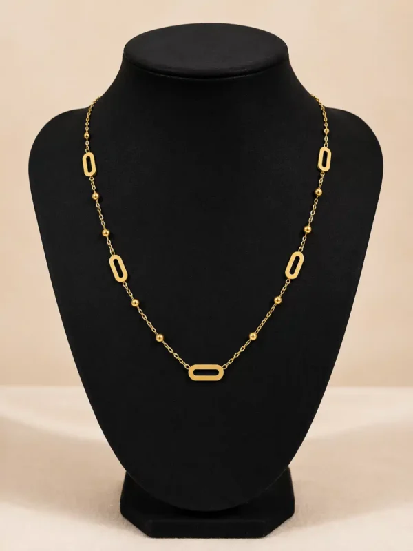 Aurelia minimal gold station necklace displayed on black bust showing five open links and bead stations