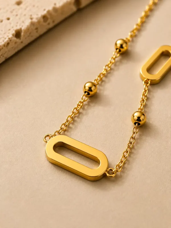 Anti-tarnish gold link and bead station necklace with horizontal centre link and symmetrical open side links