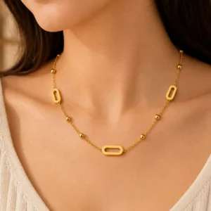 Aurelia anti-tarnish gold station necklace with open links and polished bead details worn on a woman