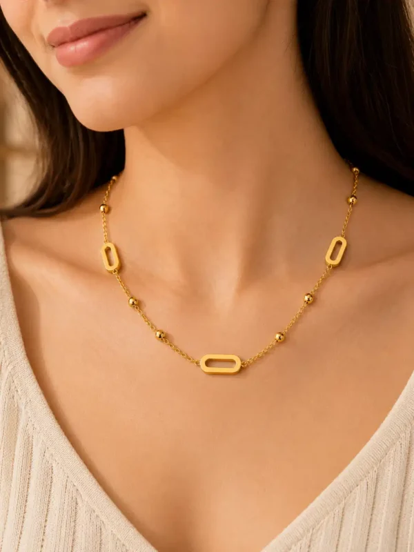 Aurelia anti-tarnish gold station necklace with open links and polished bead details worn on a woman
