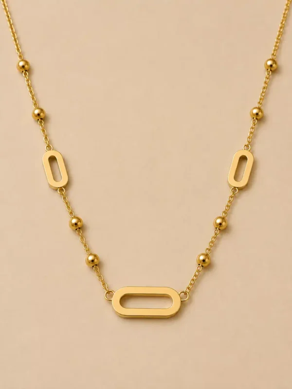 Close-up of polished horizontal open link and gold bead stations on Aurelia station necklace