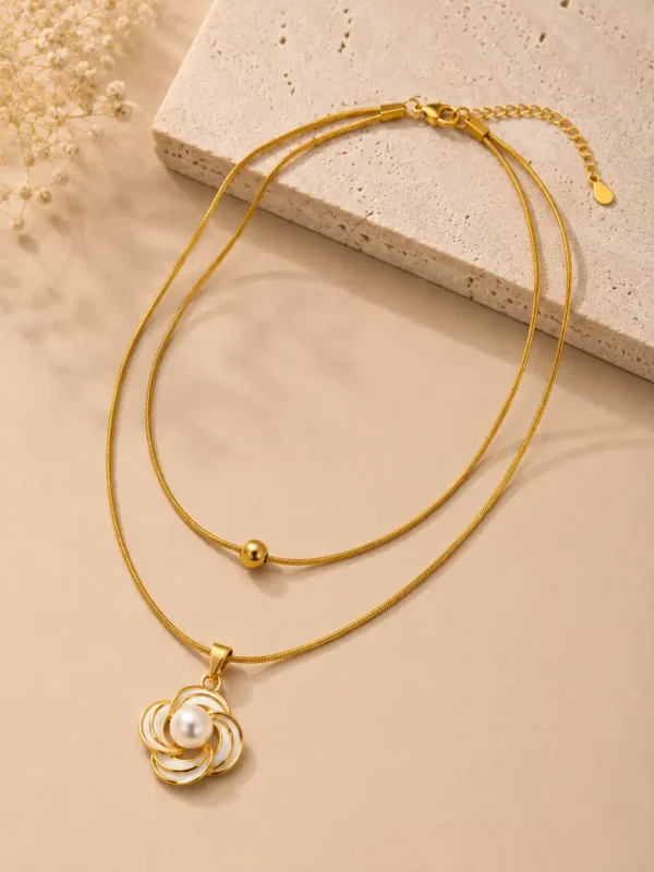 Angled flat lay of Elara anti-tarnish double-layer gold necklace with pearl flower pendant and centre bead
