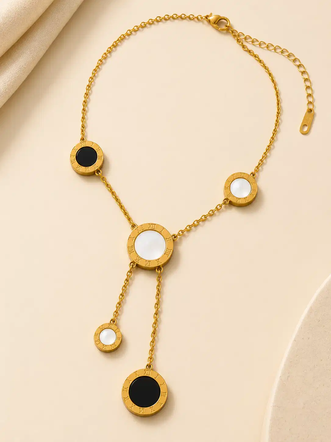 Full Vera gold lariat necklace with black and white circular Roman numeral accents, lobster clasp and extender chain
