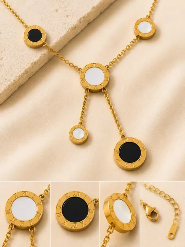 Close-up of Vera gold necklace showing Roman numeral circles with black and white inlays and clasp details