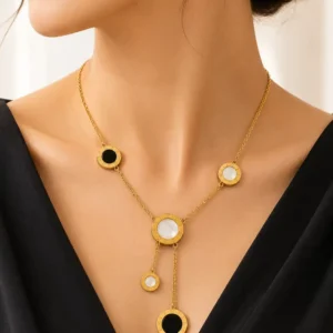 Woman wearing Vera anti-tarnish gold lariat necklace with black and white Roman numeral circle accents
