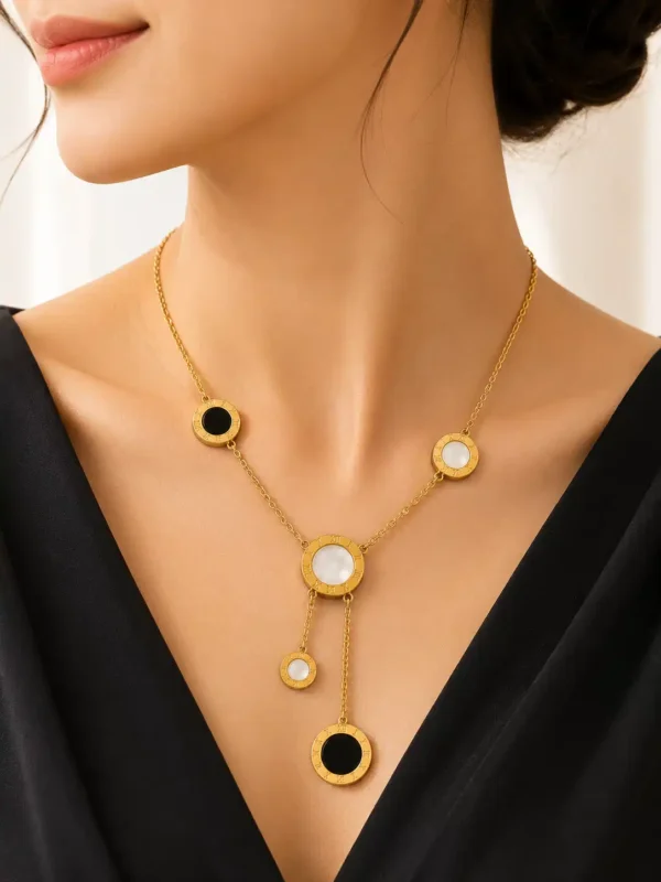 Woman wearing Vera anti-tarnish gold lariat necklace with black and white Roman numeral circle accents