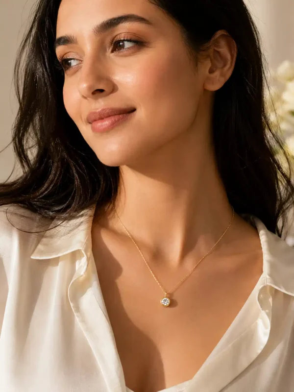 Woman wearing a minimal gold-tone solitaire pendant necklace with a white shirt for a polished everyday look