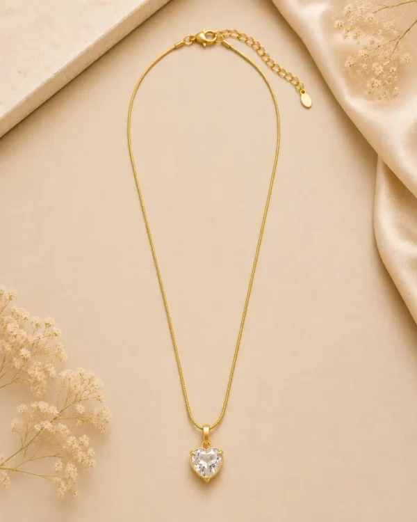 Full view of Amora gold-tone crystal heart necklace with delicate chain, lobster clasp and extension chain