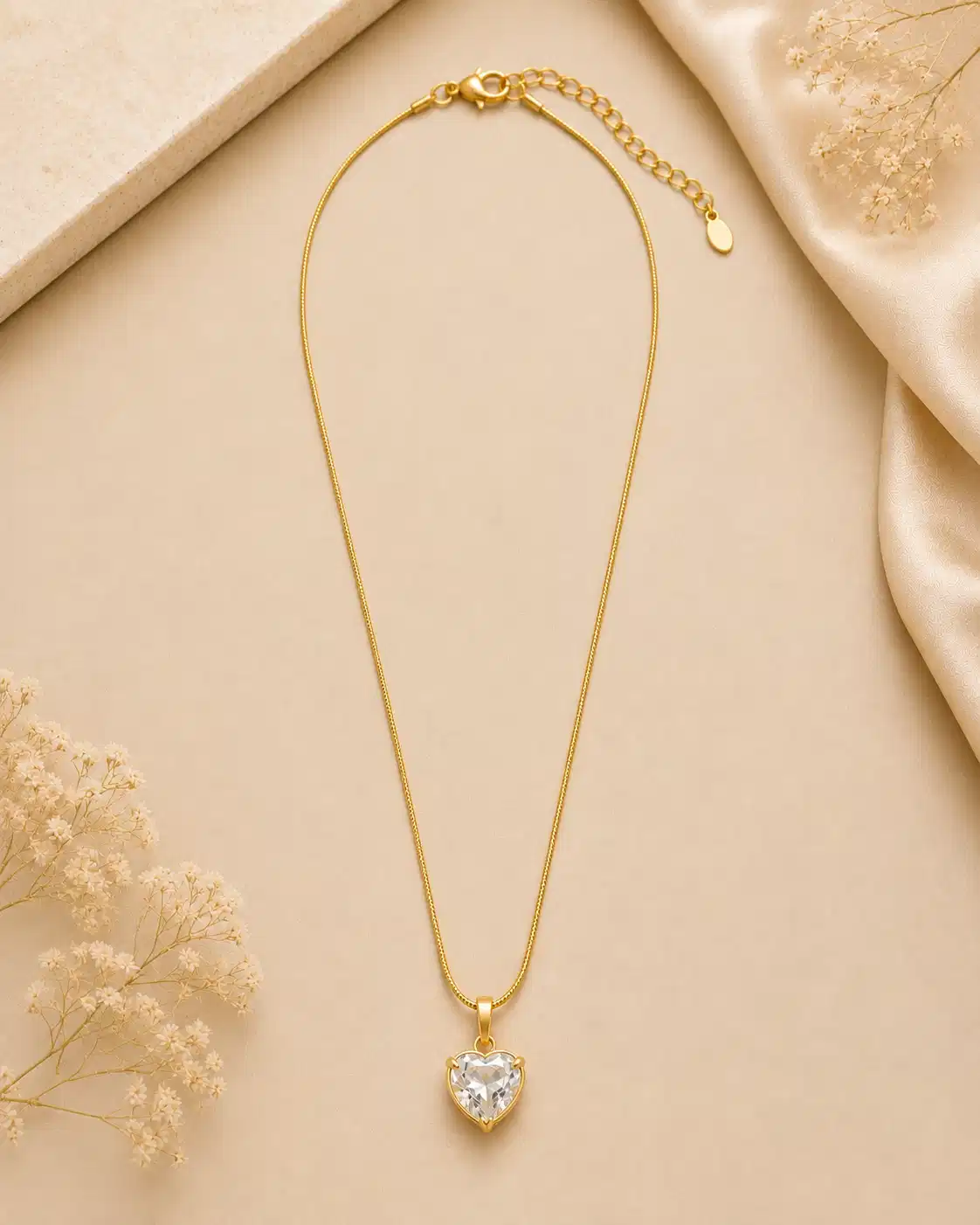 Full view of Amora gold-tone crystal heart necklace with delicate chain, lobster clasp and extension chain