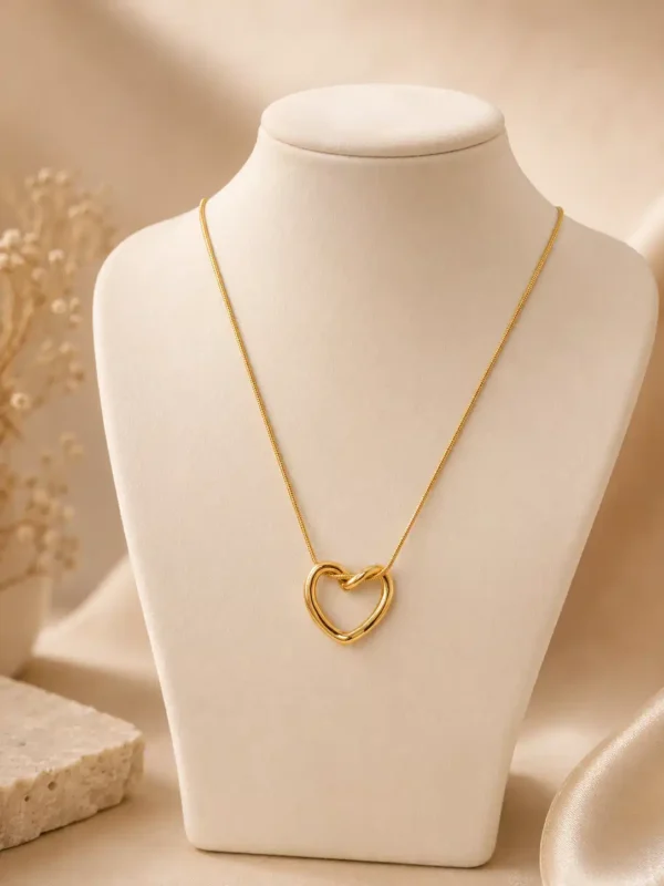 Elara gold open heart necklace displayed on cream jewellery bust