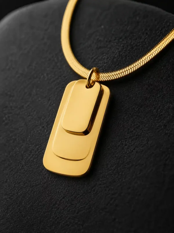 Close-up of the Linea gold-tone pendant showing three separate layered rectangular plates suspended from a smooth snake chain