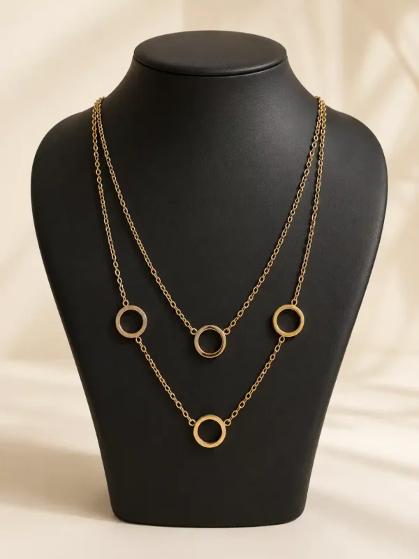 Anti-tarnish gold-plated dual-layer necklace with four open circle charms displayed on a black jewellery bust