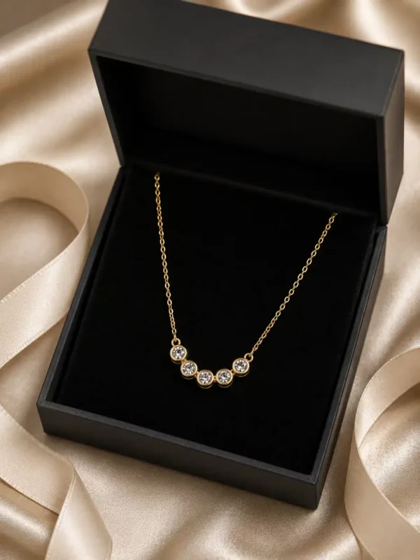 Aurelia five-stone crystal necklace presented in a black jewellery box on champagne satin
