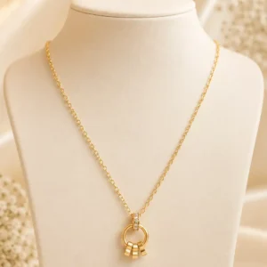 Elara anti-tarnish gold pendant necklace with crystal-accented circular charm and three dangling gold details