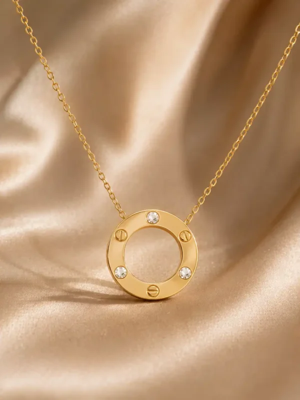 Gold circle pendant necklace with three crystal accents and screw motif detailing on a fine chain