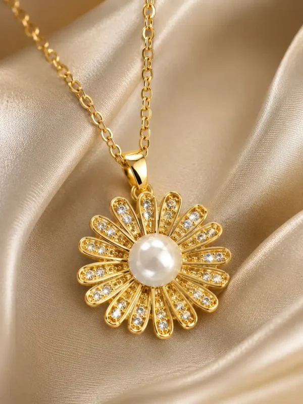 Close-up of gold flower pendant with pearl centre and crystal-studded petals