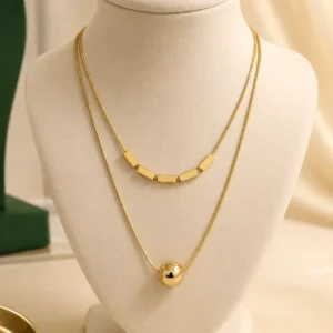 Aurevia Duo anti-tarnish gold-tone layered necklace with five geometric bar accents and polished sphere pendant