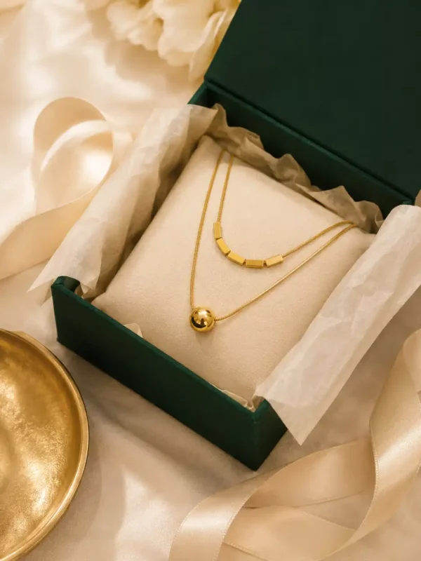 Gold-tone double-layer necklace in green presentation box with cream ribbon and gift styling