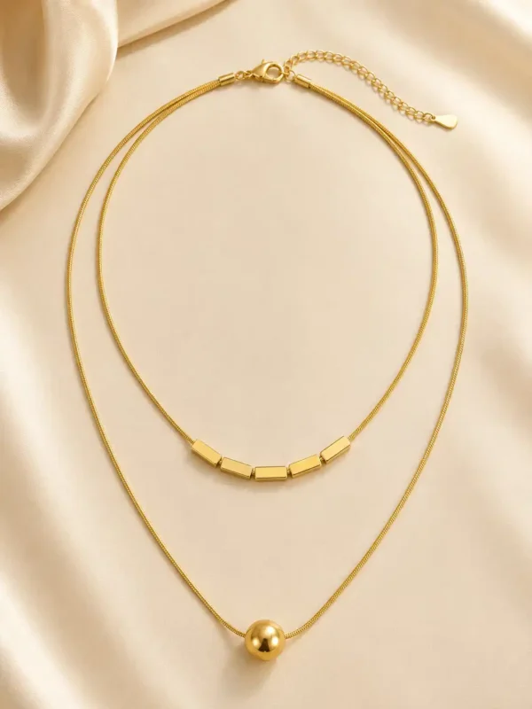Full Aurevia Duo double-layer gold-tone necklace laid flat with lobster clasp and extension chain