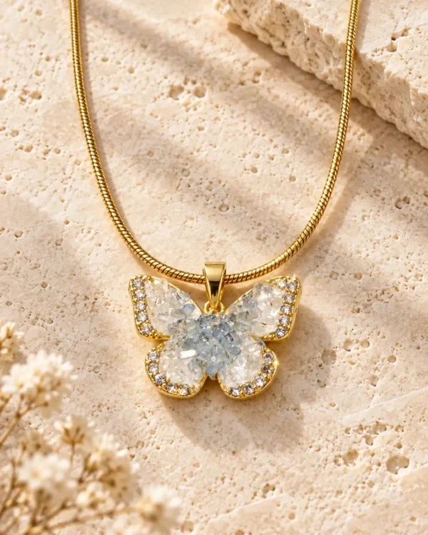 Gold-tone snake chain necklace with blue and clear crystal butterfly pendant shown in close-up