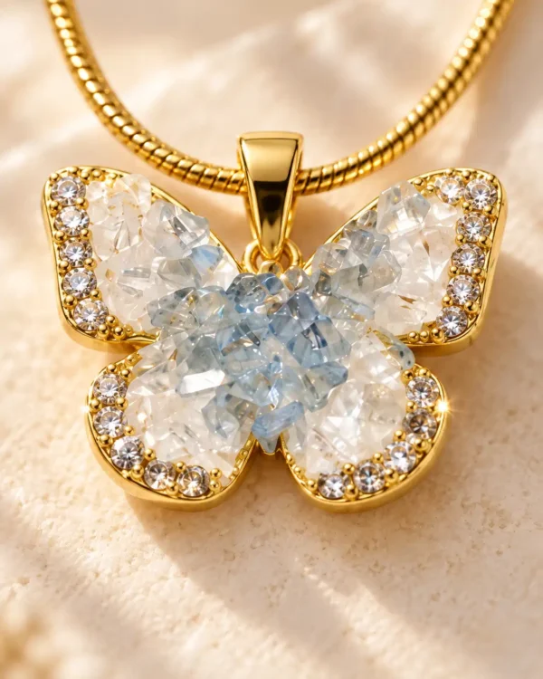 Close-up of blue and clear crystal butterfly pendant with gold-tone border and rhinestone detailing