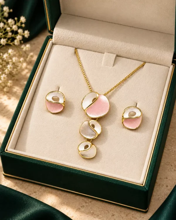 Blush Orbit pink and white pendant necklace with matching stud earrings displayed together in a green jewellery box