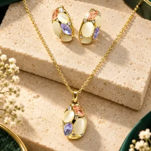 Gold-tone pendant and earring set with cream, peach, purple and clear stones arranged on beige stone