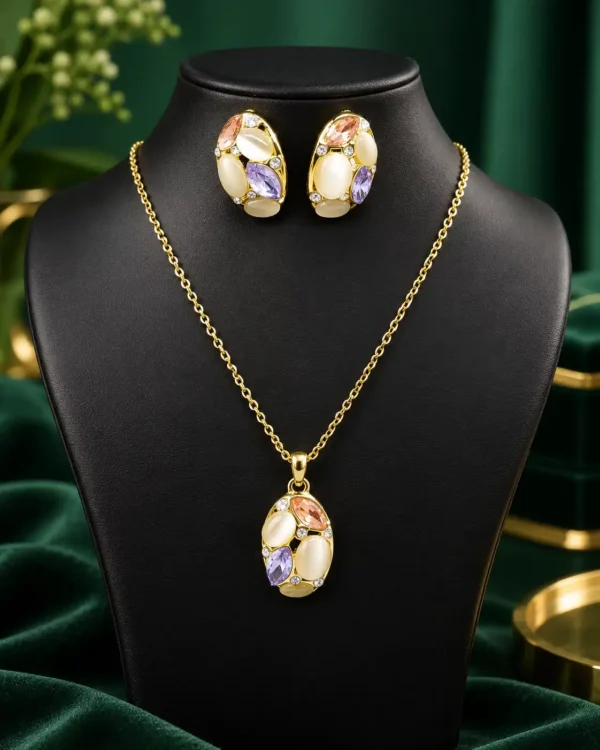 Gold-tone pastel stone necklace and matching earrings displayed together on a black jewellery bust